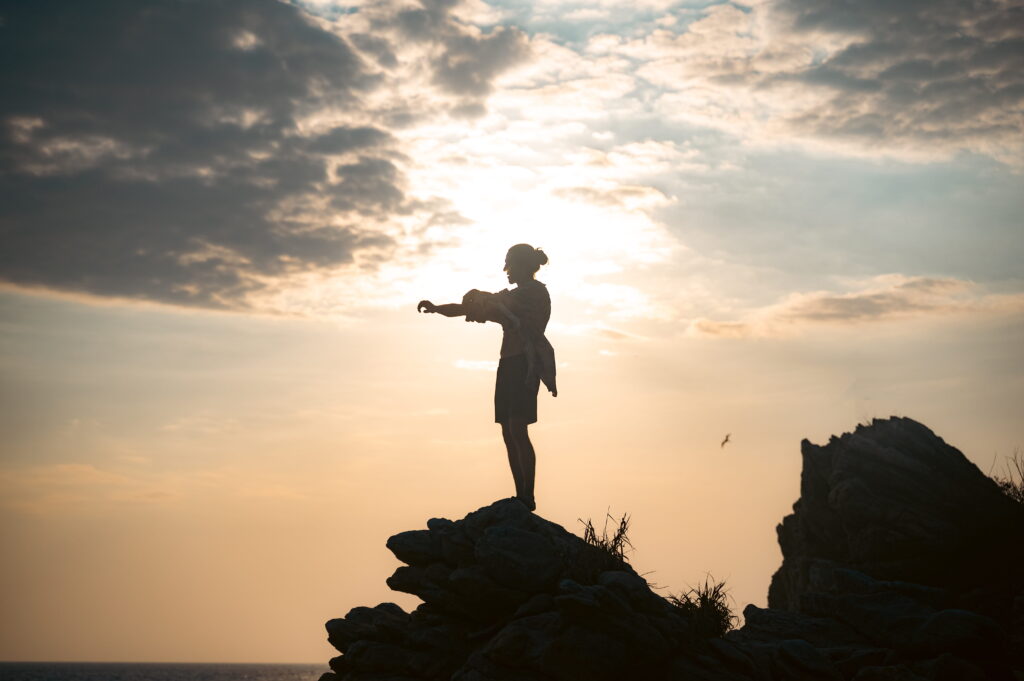 Nico als Silhouette auf einem Berg vor goldener Sonne, Symbol für Präsenz und inneren Weg