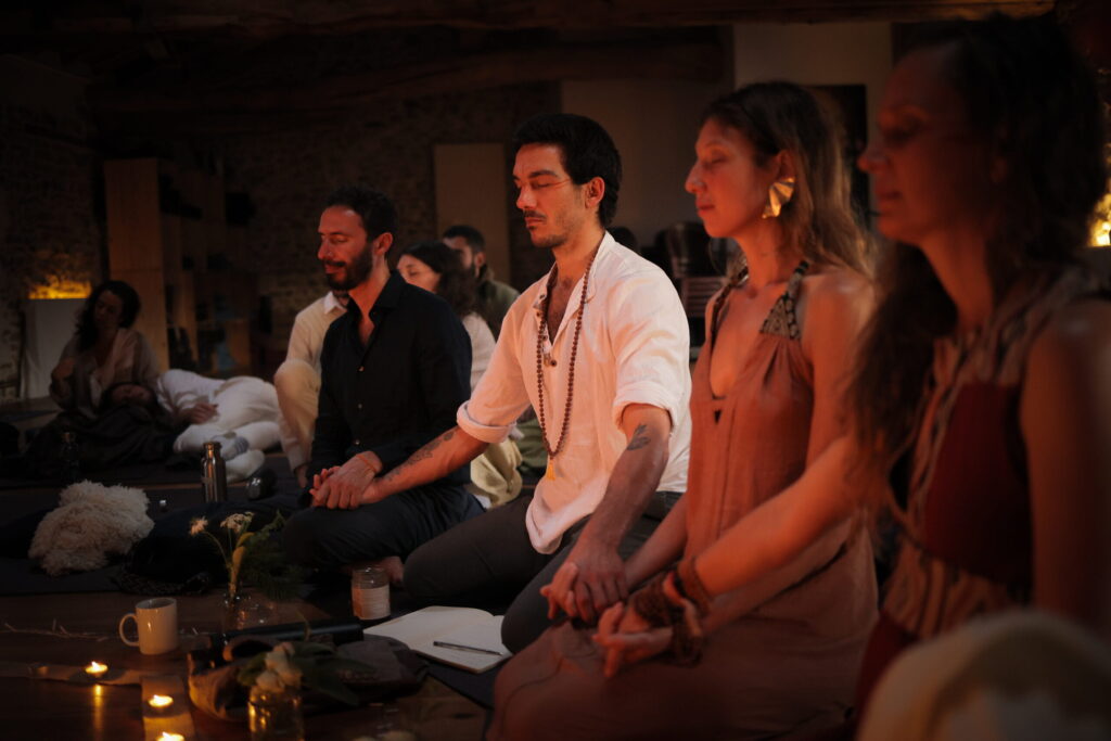 Participants sit together during a Bhajan night, singing mantras in a mindfully held workshop space