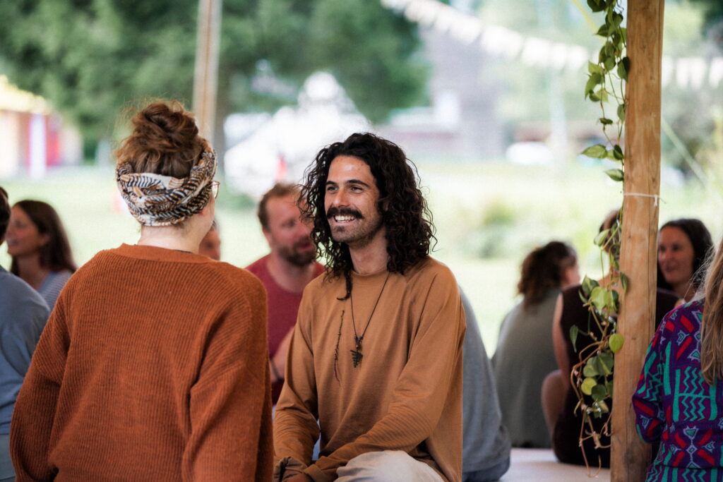 Two participants sharing during a Tantra workshop, sitting opposite each other in conscious dialogue