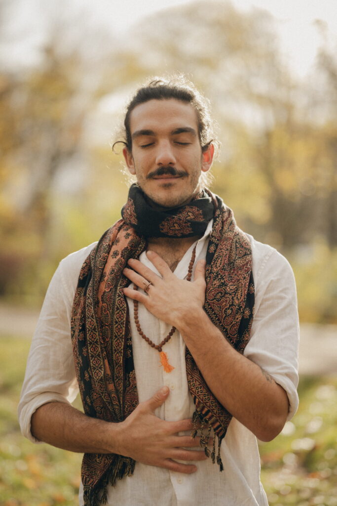 Nico Loewer mit geschlossenen Augen, eine Hand auf dem Herzen und eine auf dem Bauch