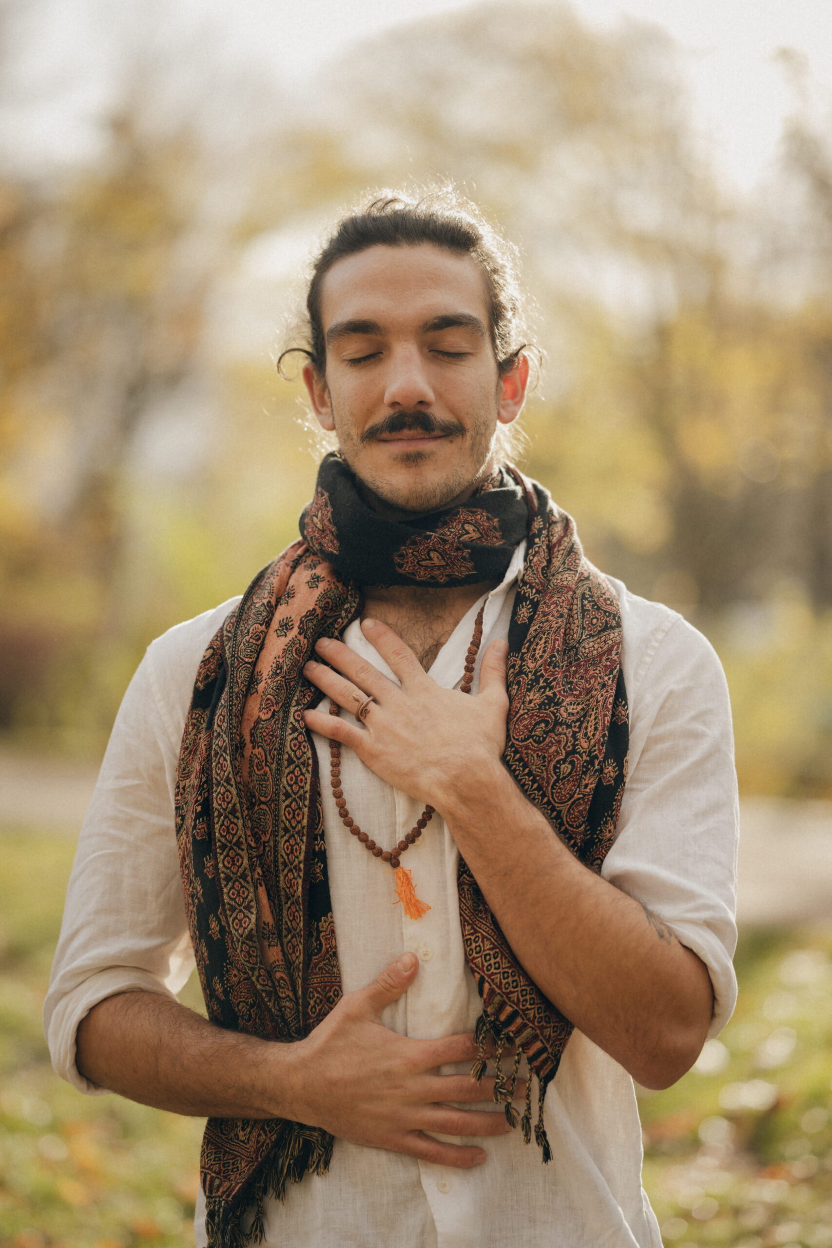Nico Loewer mit geschlossenen Augen, eine Hand auf dem Herzen und eine auf dem Bauch