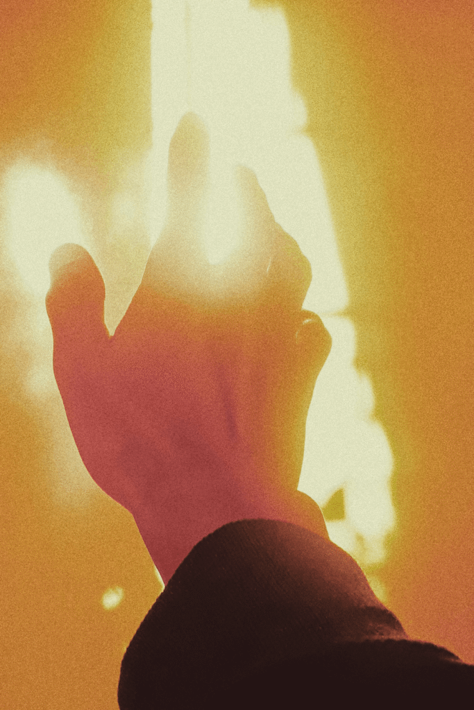 Hand reaching into the backlight as a symbol of inner alignment, self-empowerment, and conscious connection to one’s own light