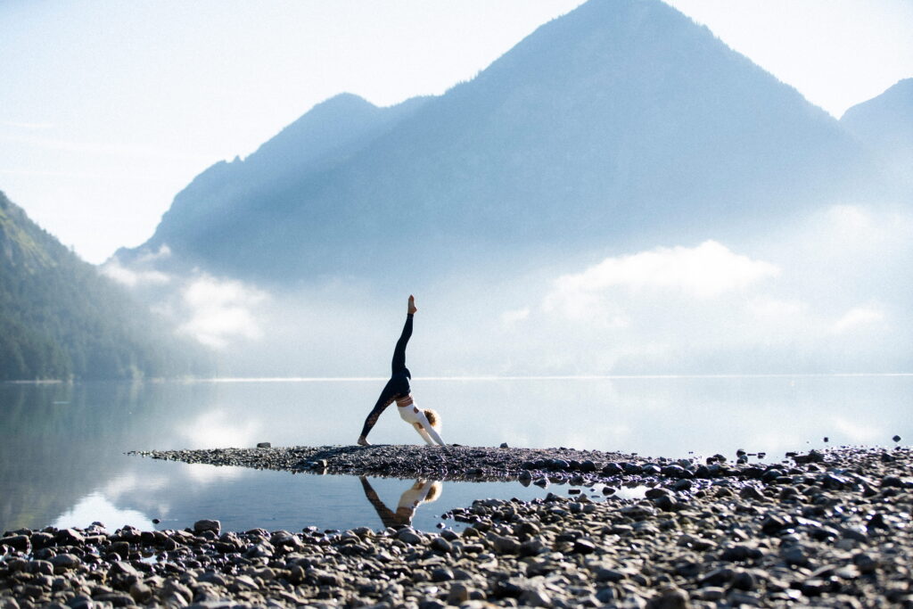 Yoga Pose am See mit Bergen